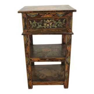 Front view of painted wood accent table with floral drawer and two shelves