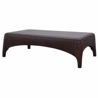Three-quarter view of the Reeva coffee table with broad top, carved perimeter, softened corners, and sweeping arched base.